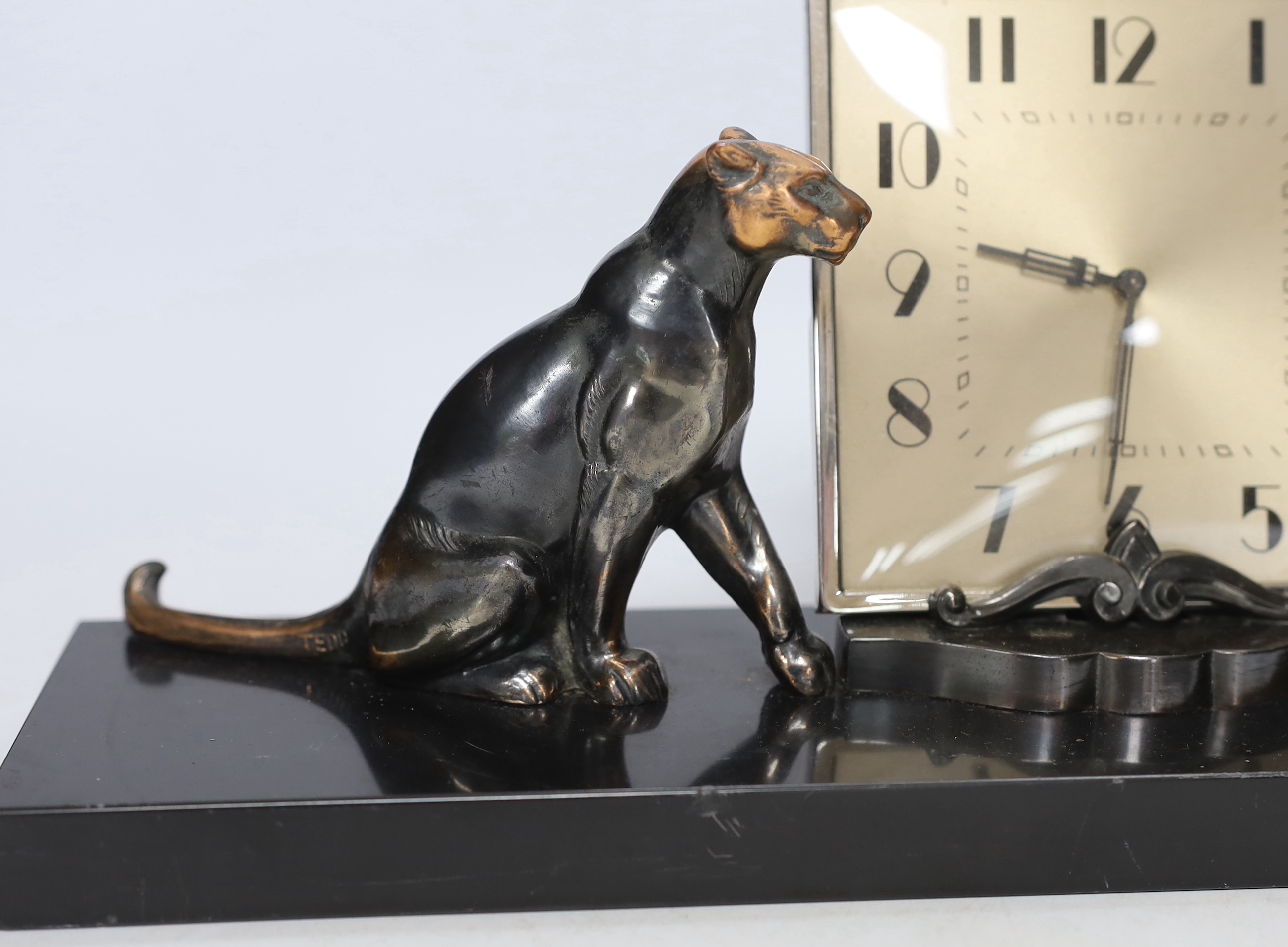 A patinated spelter Art Deco clock surmounted with two panthers, 40cm high